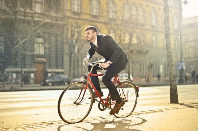 Man in suit riding bike